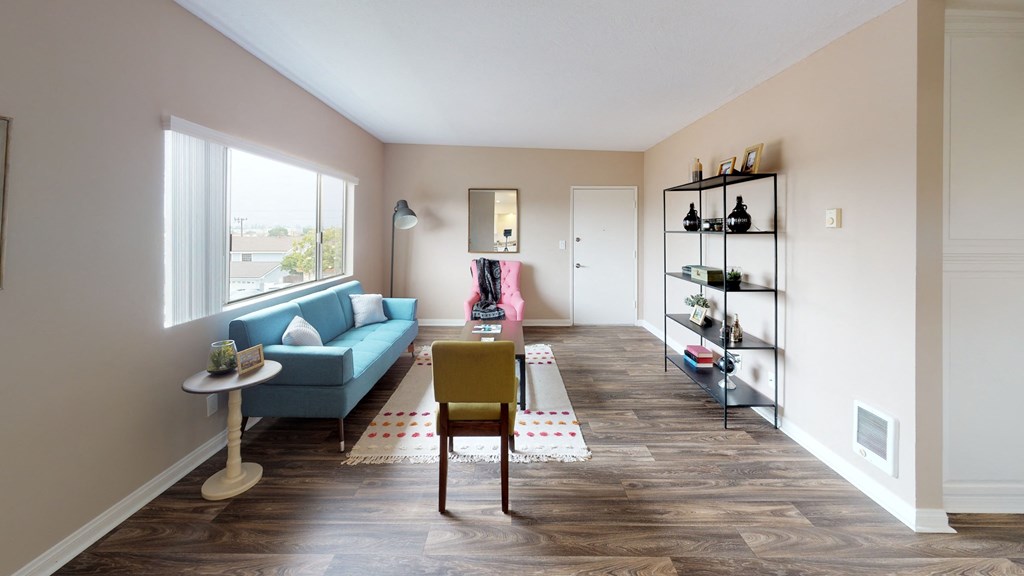 a living room with a blue couch and a table with a yellow chair