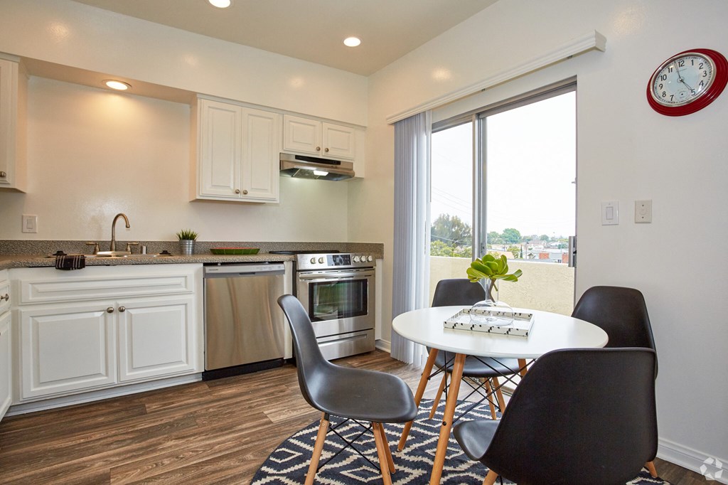 a kitchen with white cabinets and a large window