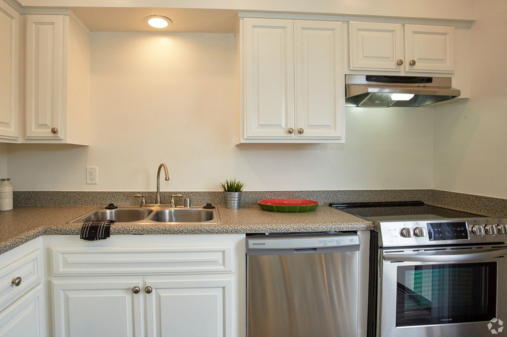a kitchen with white cabinets and stainless steel appliances