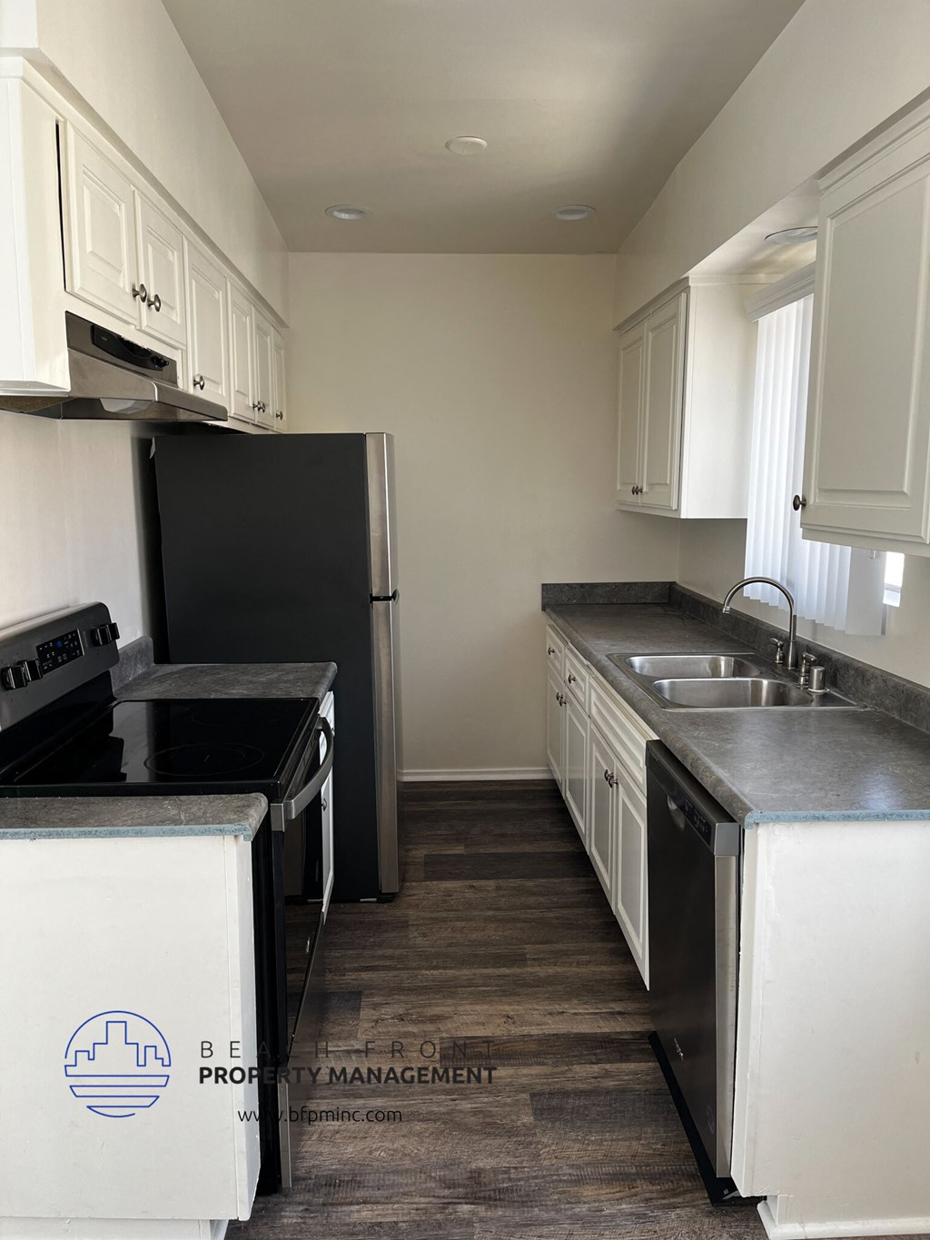 a kitchen with white cabinets and black appliances
