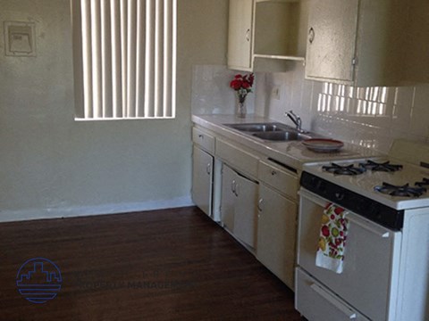 a kitchen with a stove and a sink and a window