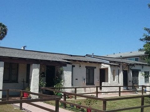 a small house with a porch and a wooden fence