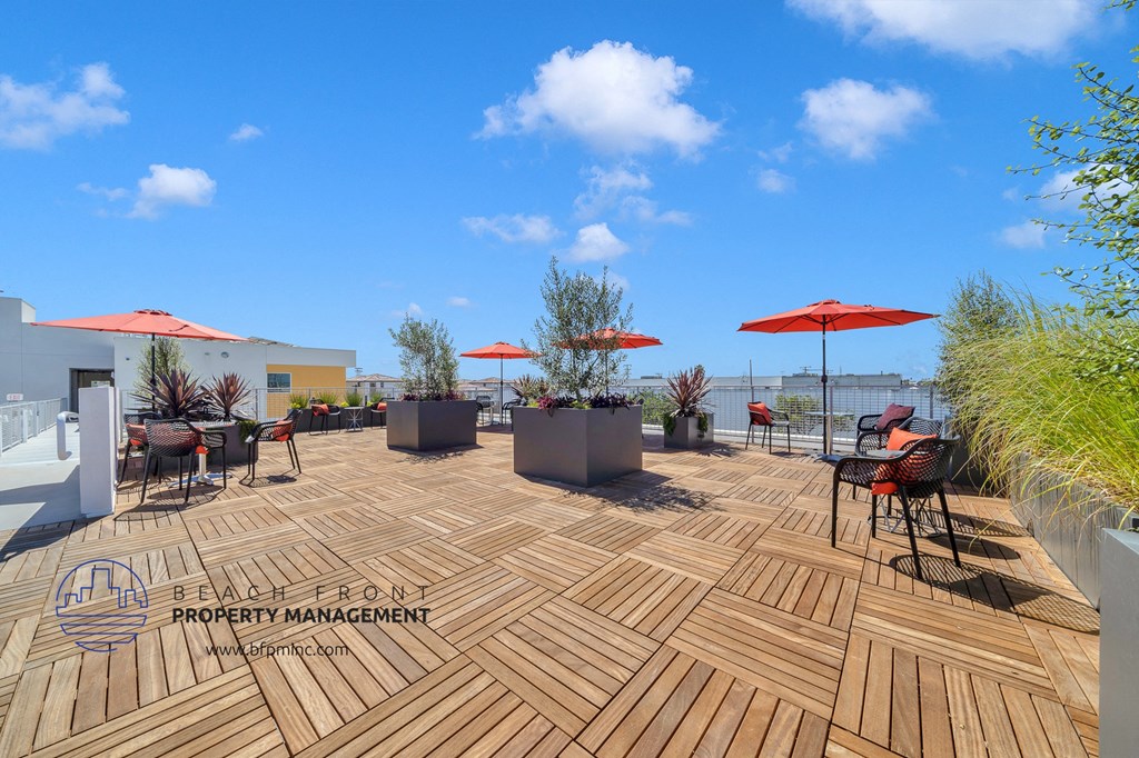 a roof terrace with tables and umbrellas on a sunny day
