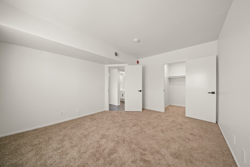 an empty living room with white walls and carpet