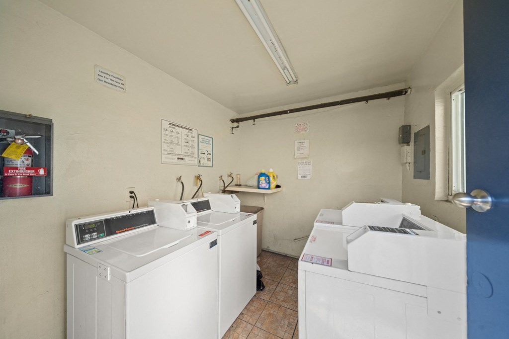 a laundry room with three washes and two dryers in it