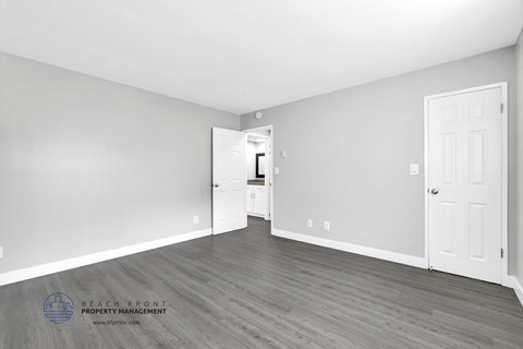 a bedroom with hardwood floors and grey walls