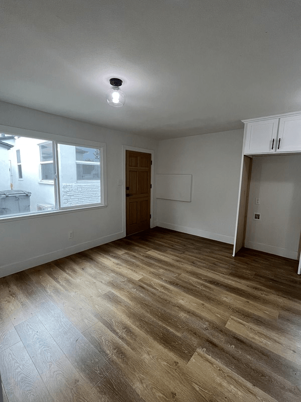 an empty room with a large window and white walls