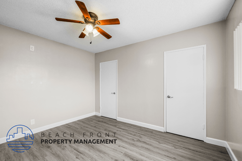 a bedroom with a ceiling fan and a door to a closet