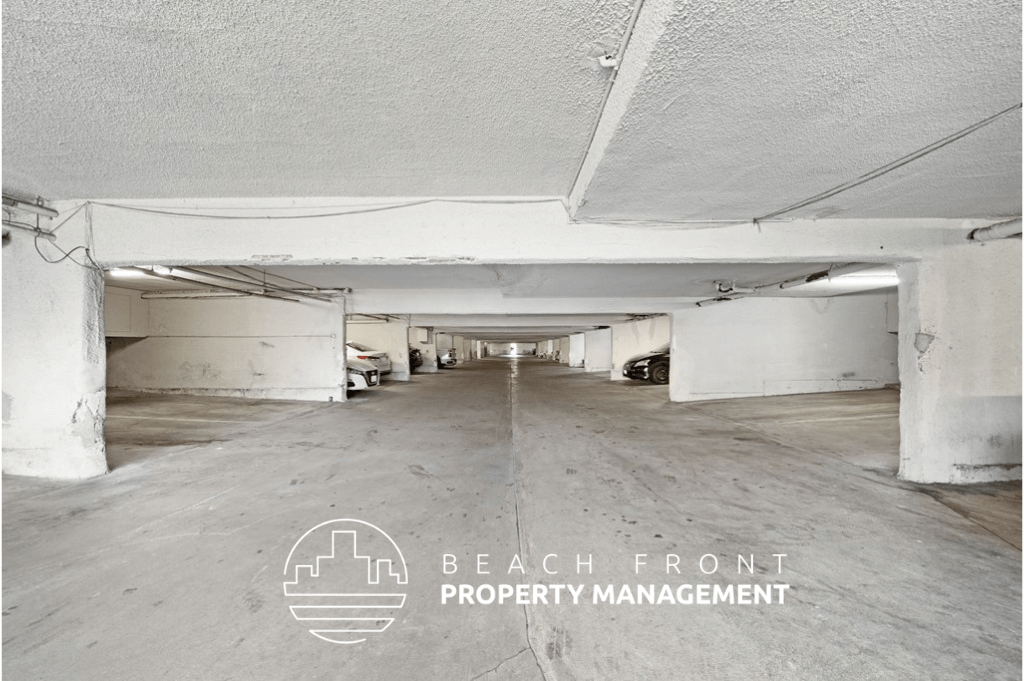 the inside of a parking garage with the beach front property management logo