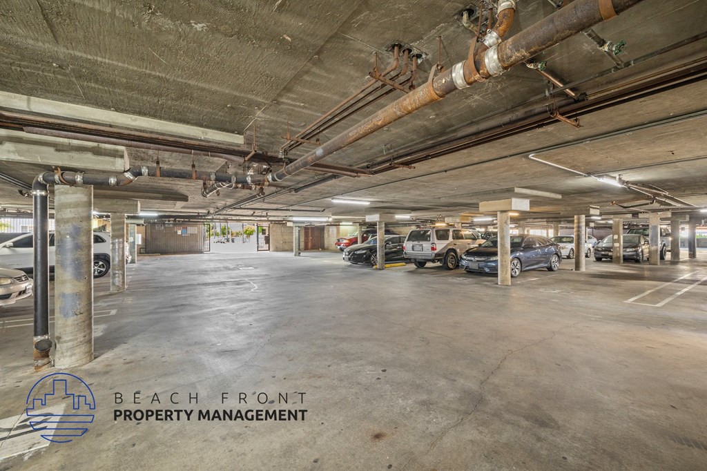 a parking garage with cars in it and the beach front property management logo