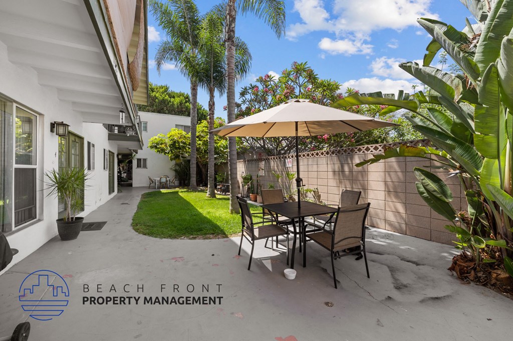 a patio with a table and chairs under an umbrella