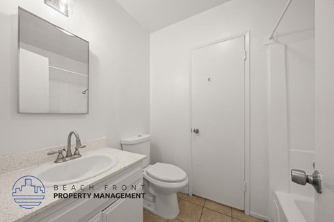 A white bathroom with a sink, toilet, and bathtub.