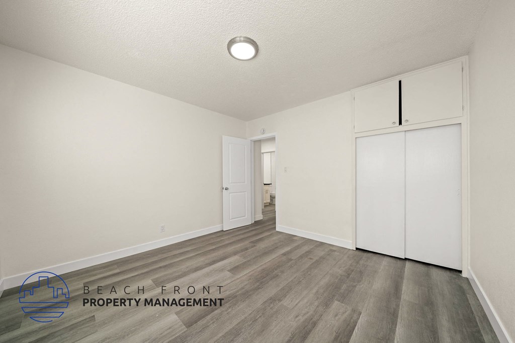 A room with a wooden floor and a white ceiling with a light fixture.