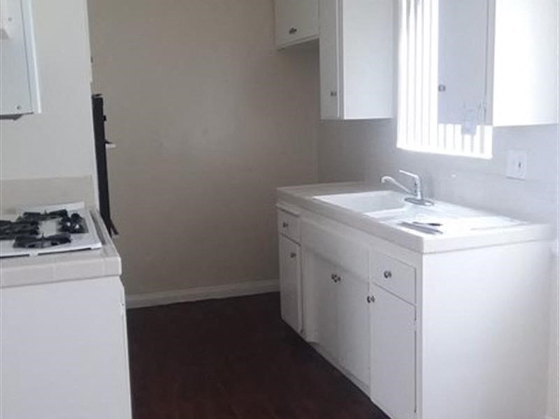 a kitchen with a stove a sink and a window