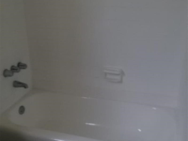 a white bath tub sitting next to a white wall