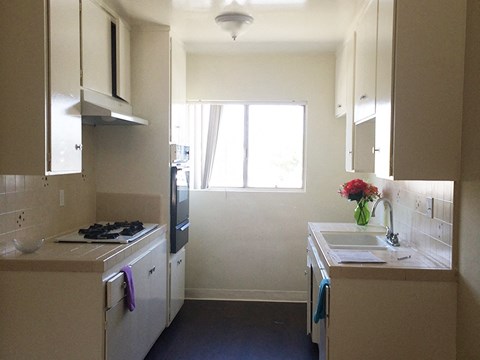 a kitchen with a stove and a sink and a window