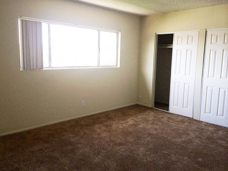 an empty room with a window and a closet