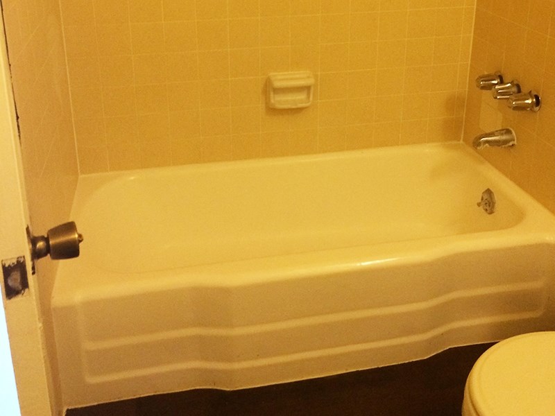 a white bath tub sitting next to a toilet