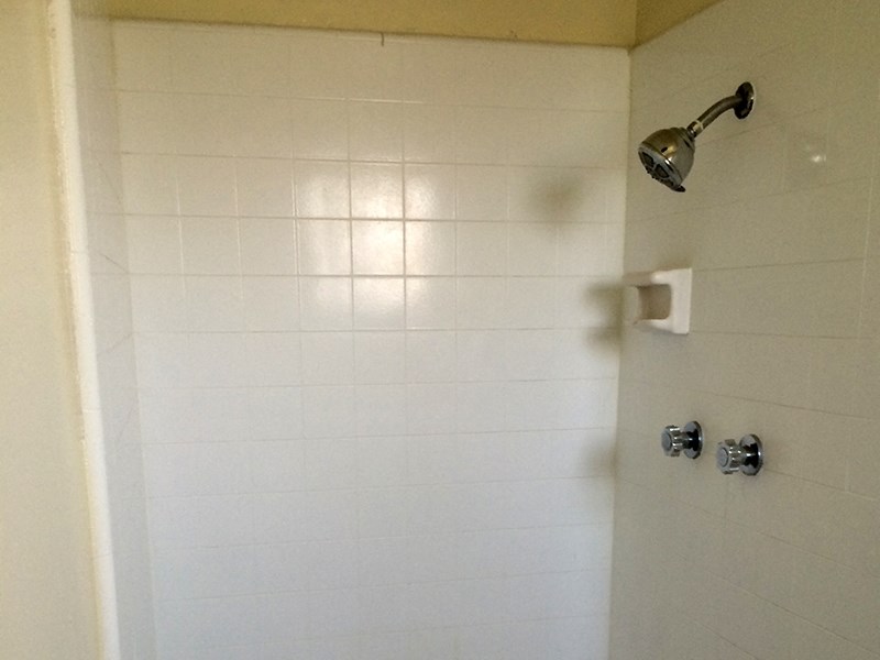 a white tiled shower in a bathroom