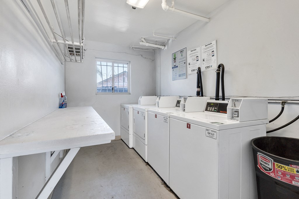 a laundry room with washers and dryers and a counter