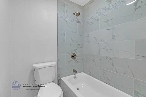 a bathroom with a tub and a toilet in it