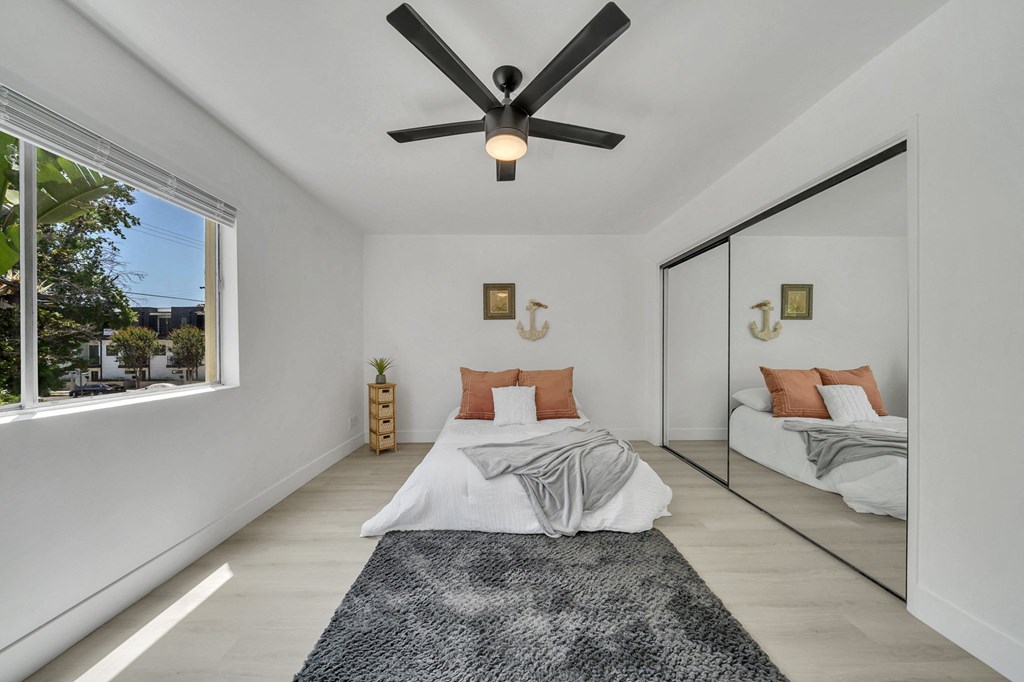 a bedroom with two beds and a ceiling fan