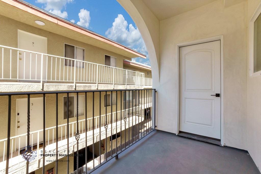 a balcony with a white door and a guard rail