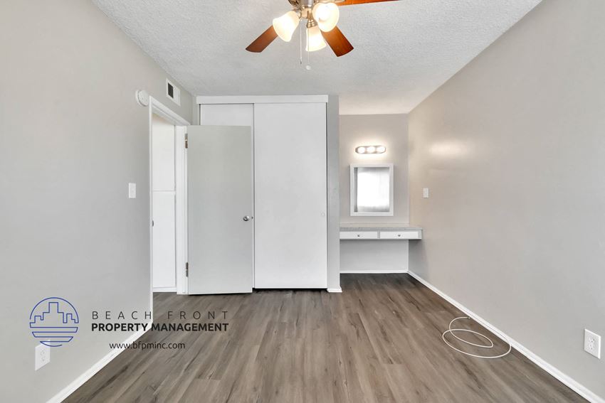 a white bathroom with a white closet and a ceiling fan