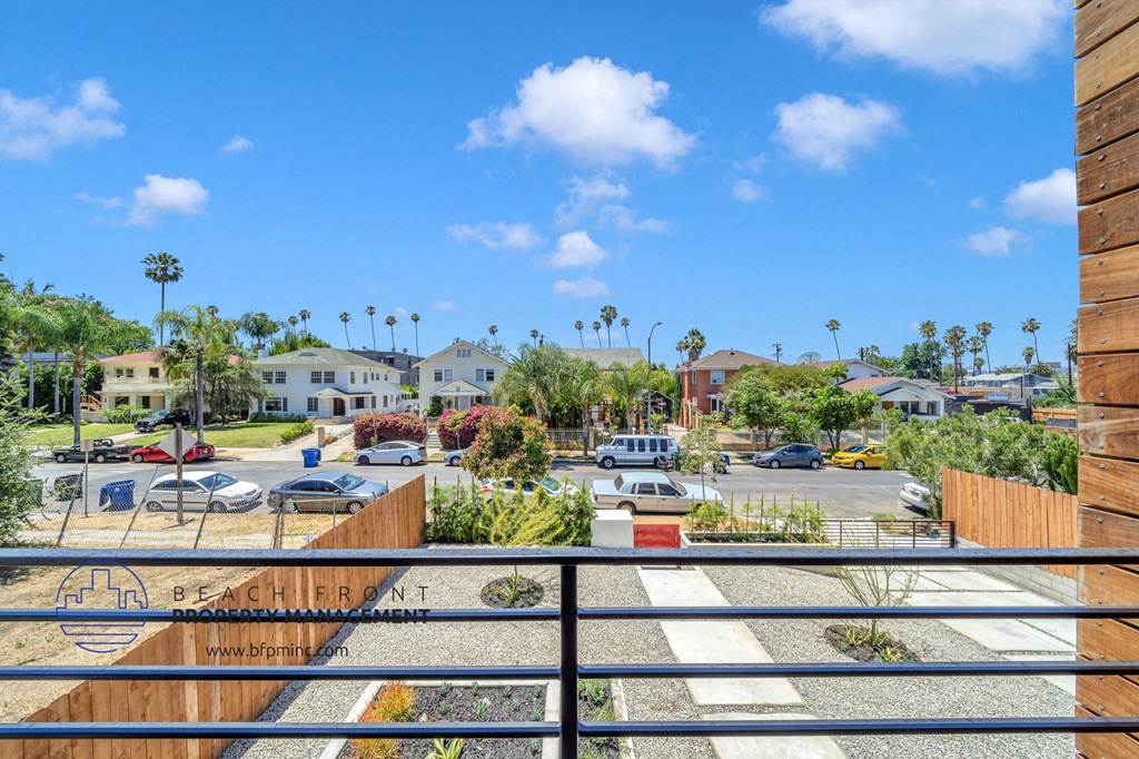 a view of the parking lot from the balcony of a building with cars in the