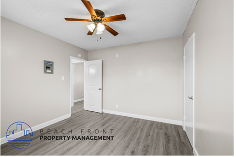 an empty room with a ceiling fan and a door
