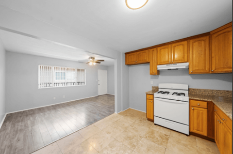 A kitchen with a white oven and wooden cabinets.