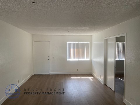 A room with a window and a door, managed by Beach Front Property Management.