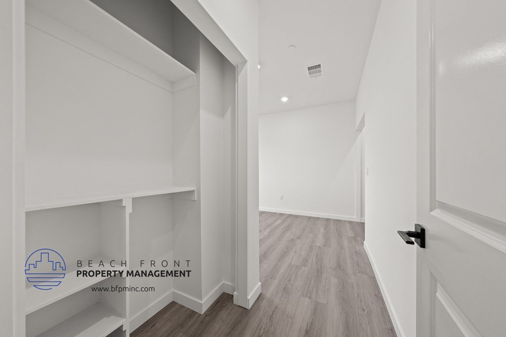 a white hallway with white walls and wood flooring