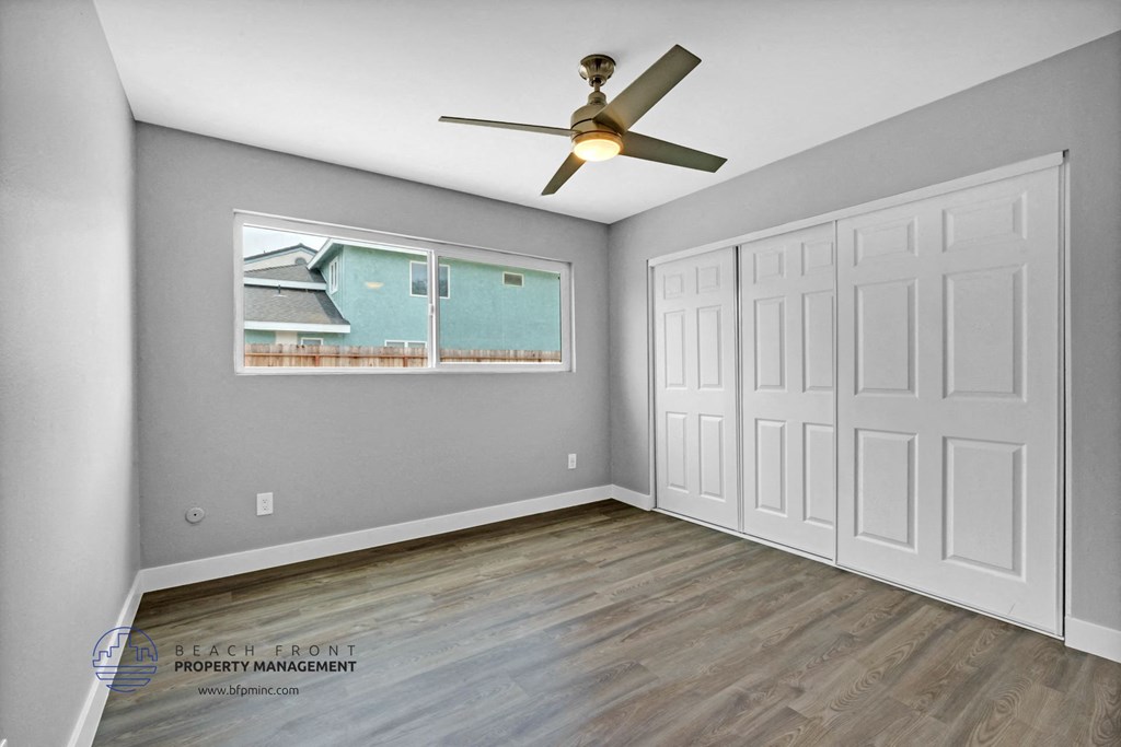 a bedroom with two closets and a ceiling fan