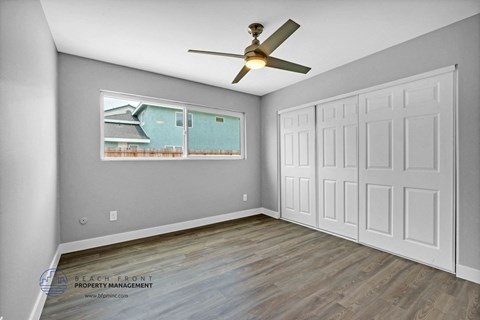 a bedroom with two closets and a ceiling fan