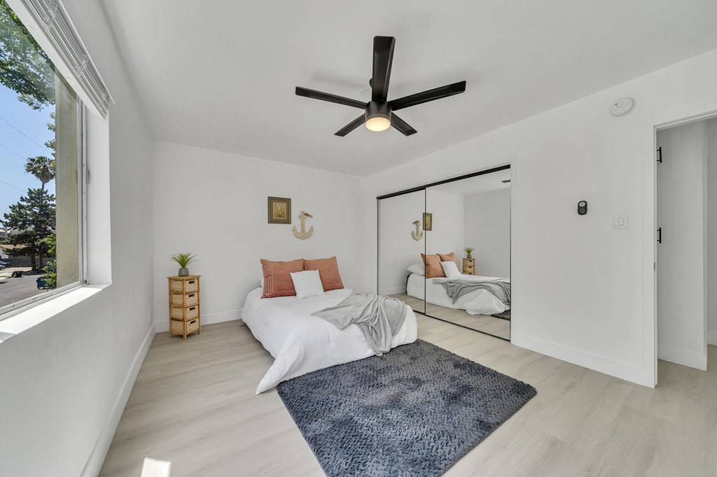 a bedroom with a bed and a ceiling fan
