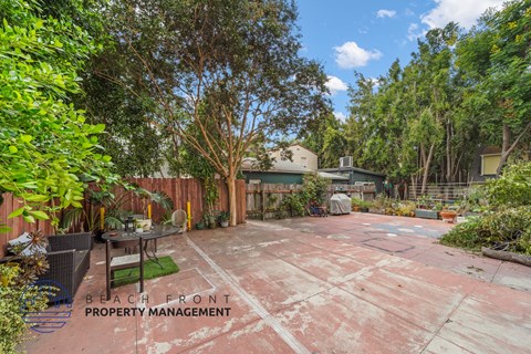 a backyard with a patio and a fence and trees