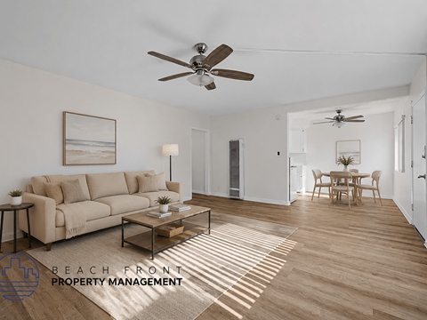 A living room with a couch, a coffee table, and a ceiling fan.