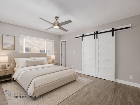 A bedroom with a bed, a ceiling fan, and a sliding door.
