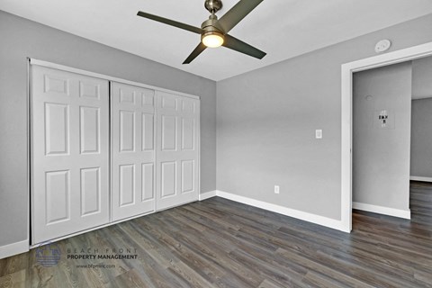 the living room of an empty house with a ceiling fan