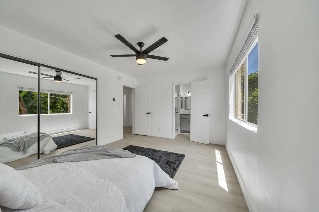 the master bedroom has a large bed and a ceiling fan