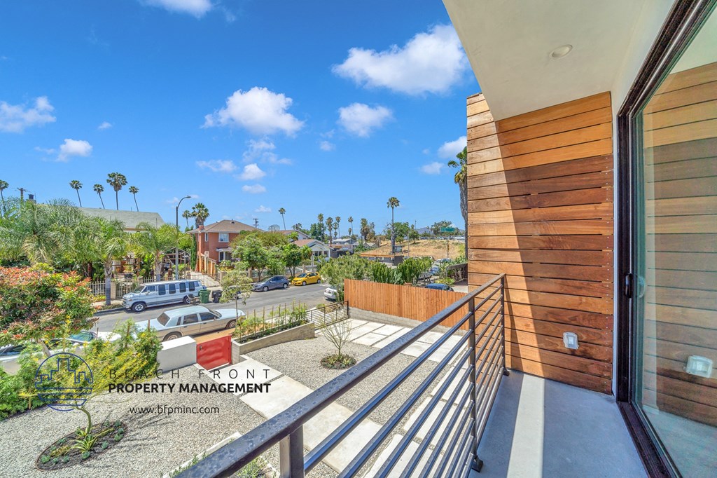 a balcony with a view of the street and palm trees