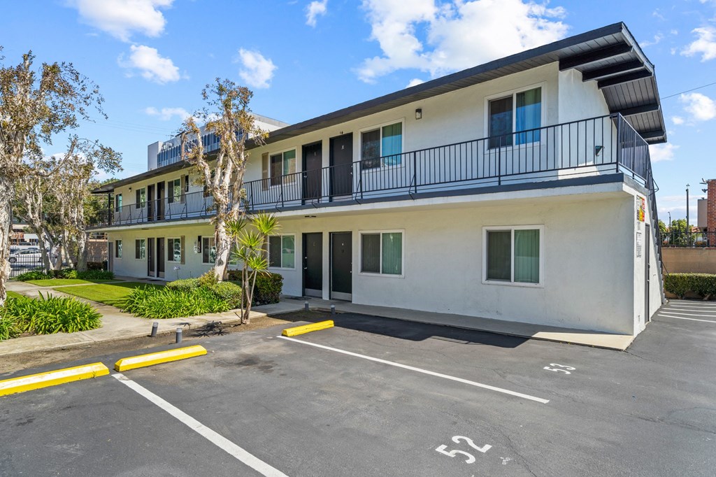 the front of an apartment building with a parking lot