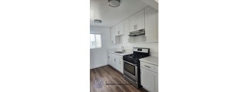 A kitchen with white cabinets and a black stove top oven.