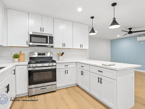A kitchen with white cabinets and a stainless steel stove.