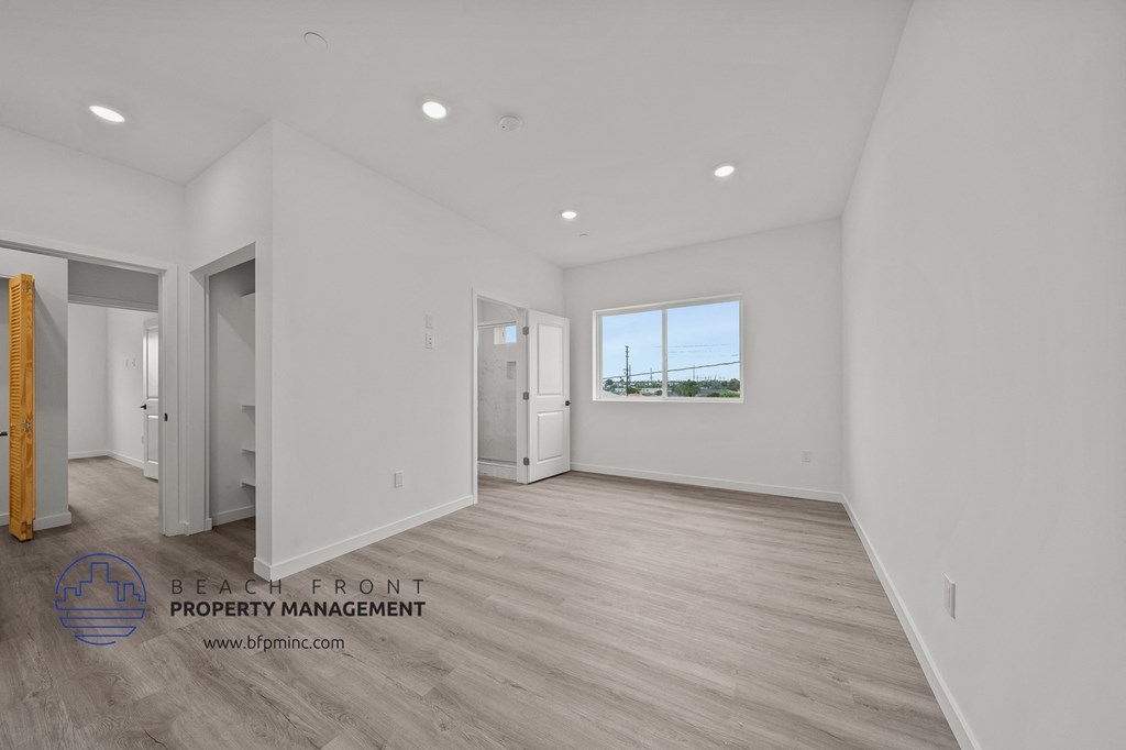 a newly renovated living room with white walls and wood flooring