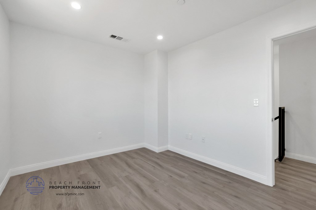 the living room of a new home with white walls and wood flooring