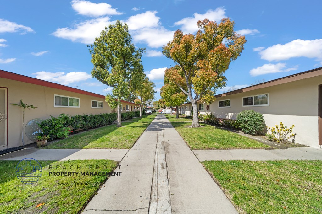 a view down a sidewalk in front of an apartment complex