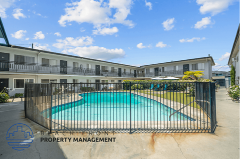 the view of a swimming pool behind a wrought iron fence