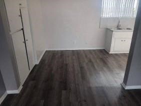 a small room with a wooden floor and a sink